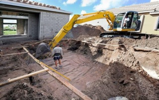 Construction worker operating a digger at a house site. Top excavation services by MBK Constructors in Ann Arbor, MI.